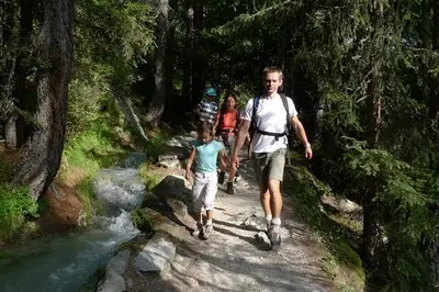 Famille en randonnée avec des ânes en montagne